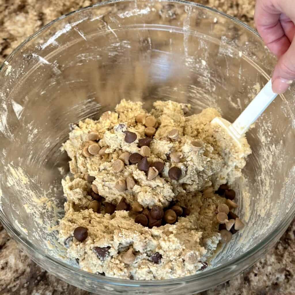 Folding chocolate and peanut butter chips in cookie dough.