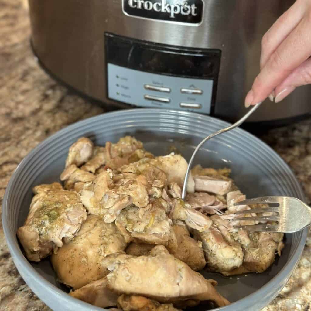 Shredding chicken in a bowl.