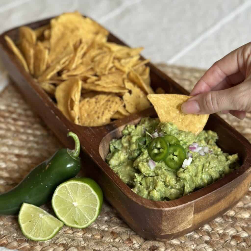 Getting a scoop of guacamole with a chip.