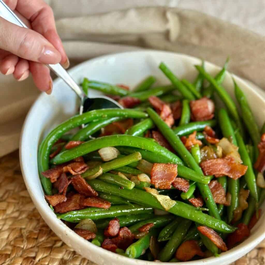 Getting a spoonful of bacon green beans.