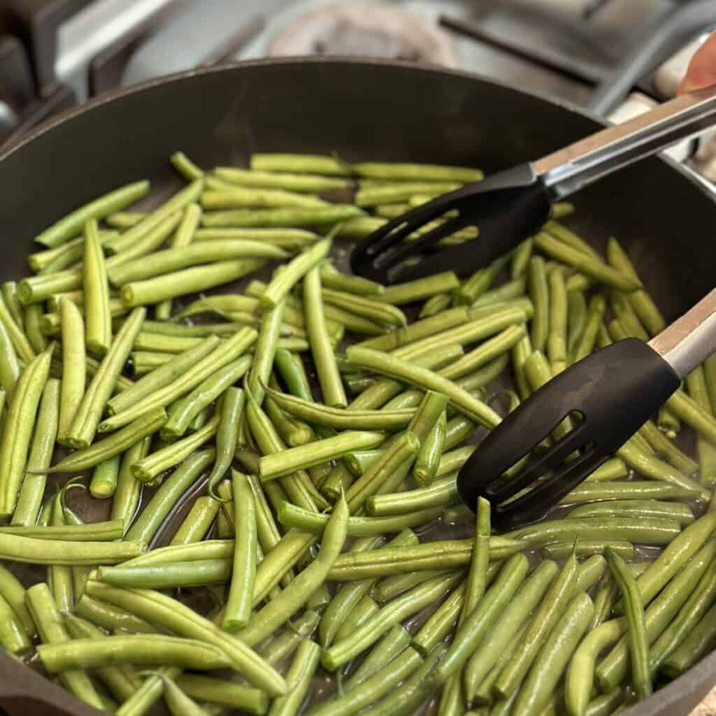 Cooking green beans in a skillet.