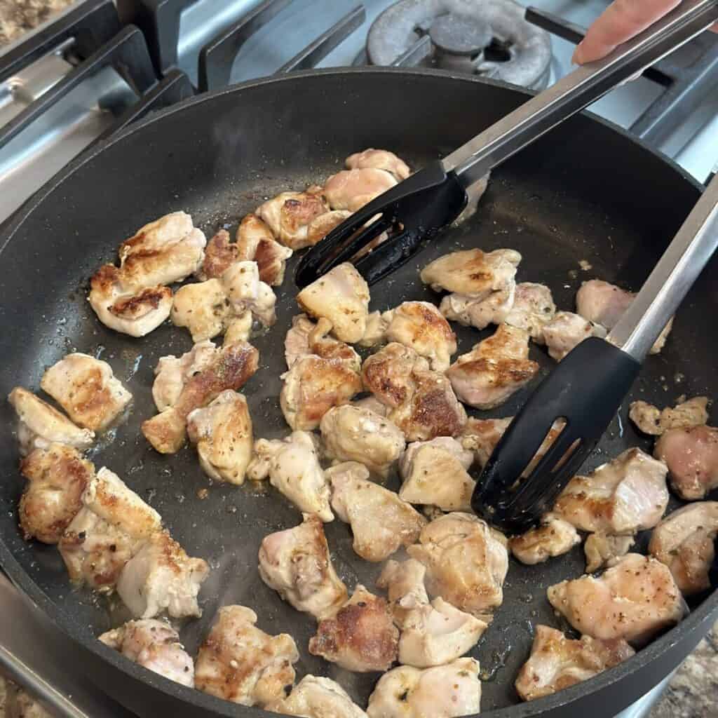 Cooking chicken in a skillet.