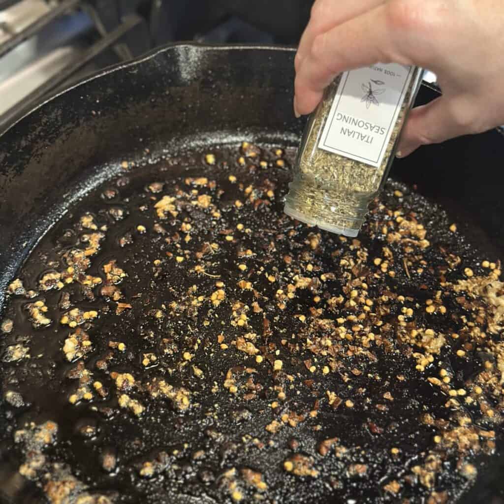 Adding seasoning to a pan.