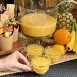 Picking up a cup of pineapple punch.