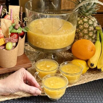 Picking up a cup of pineapple punch.
