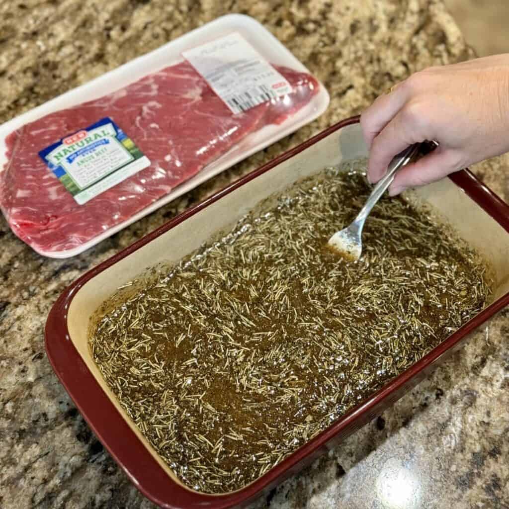 Mixing the marinade for steak in a dish.