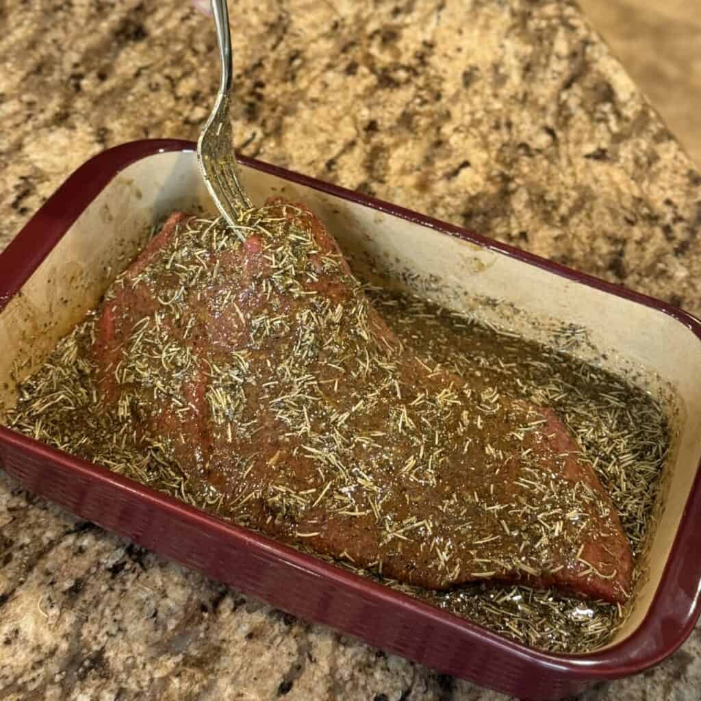 Adding flank steak to marinade.