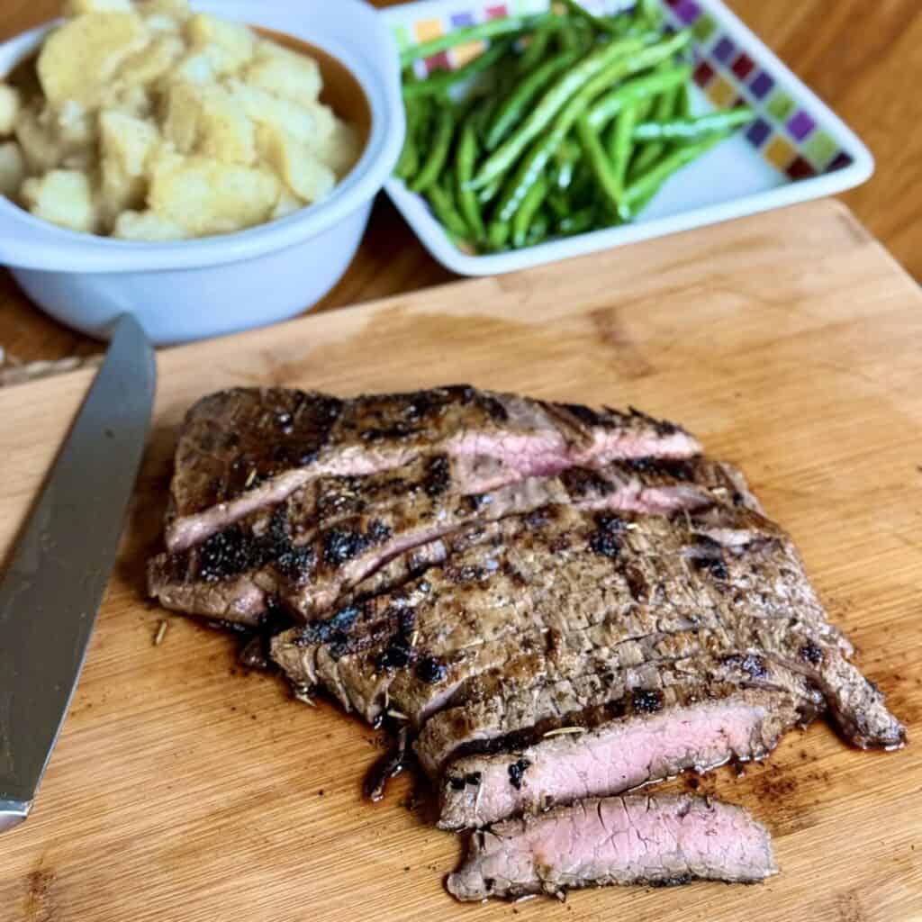 A flank steak on a cutting board.