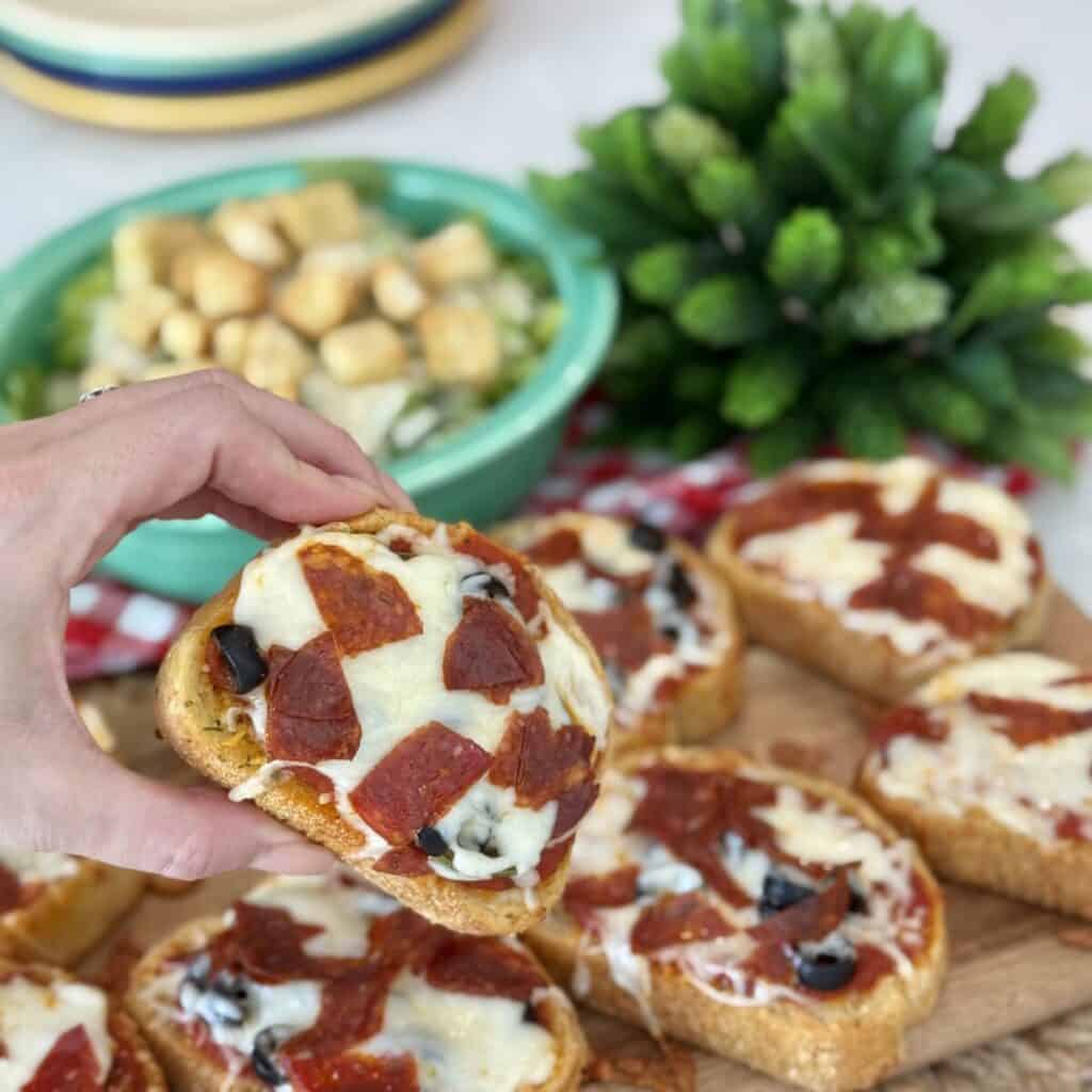 Holding a slice of Texas toast pizza.