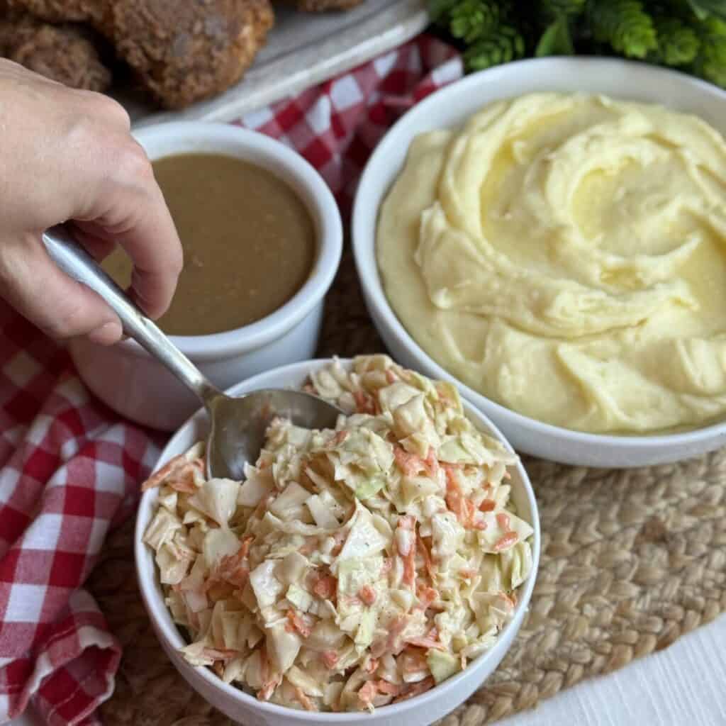 A spoon in a bowl of KFC copycat coleslaw.