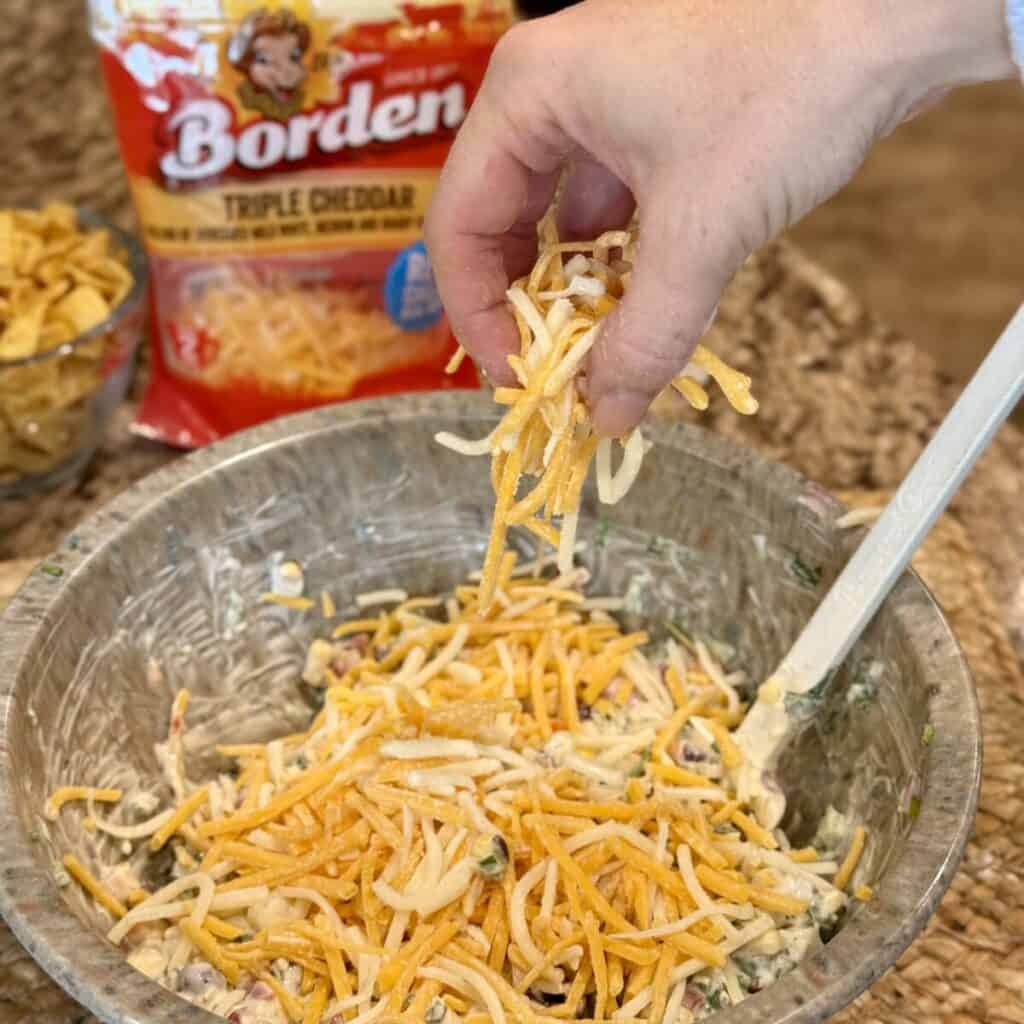 Mixing the ingredients together for corn chip salad.