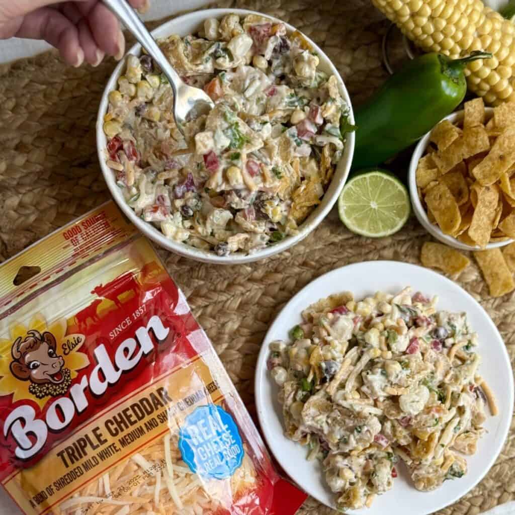 A plate and bowl of corn chip salad.