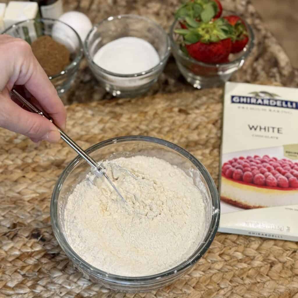 Mixing dry ingredients in a bowl for cookies.