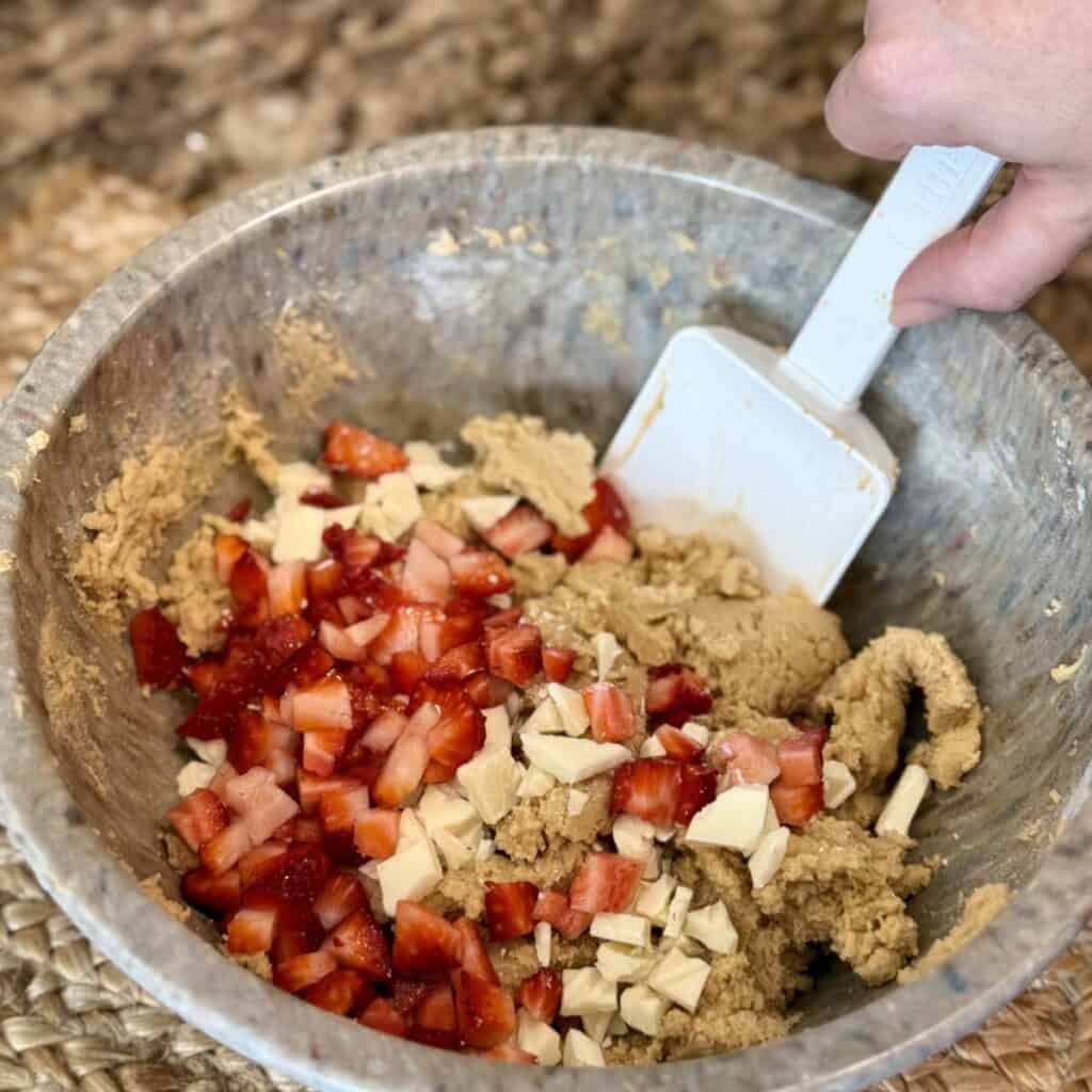 Mixing together ingredients in a bowl for strawberry shortcake cookies.