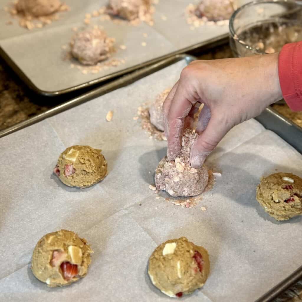 Adding streusel to the tops of cookie dough.
