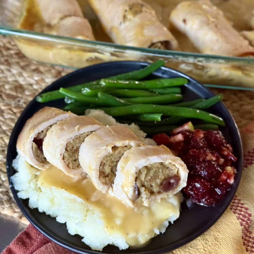 A plate of turkey rollups and homemade whole berry cranberry sauce.