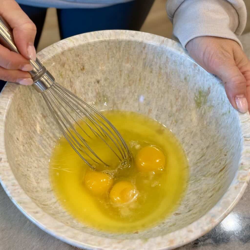 Whisking butter and eggs in a bowl.