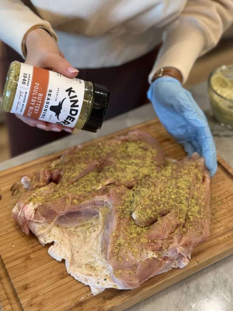 Seasoning a turkey breast.