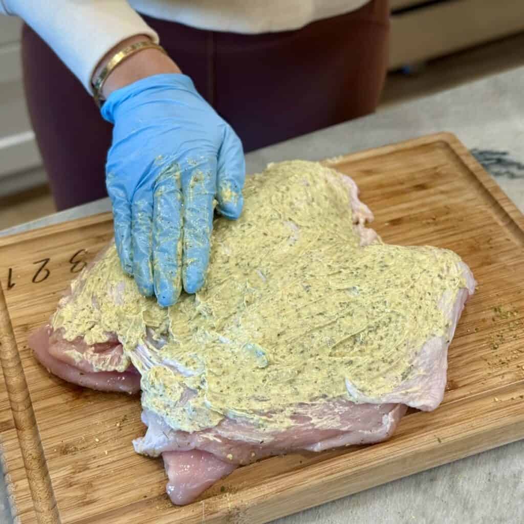 Adding butter to a turkey breast.
