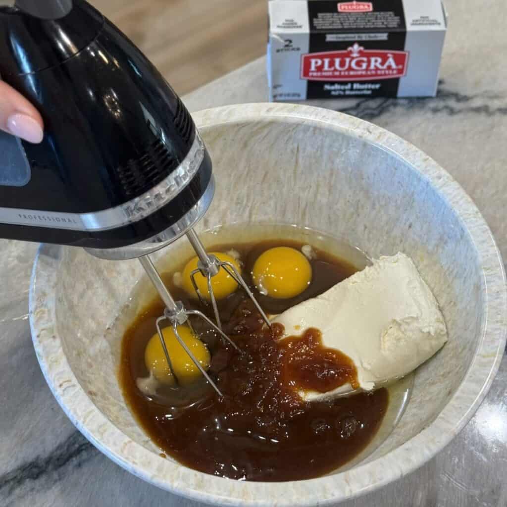 Mixing together the ingredients in a bowl for pumpkin gooey butter cake.