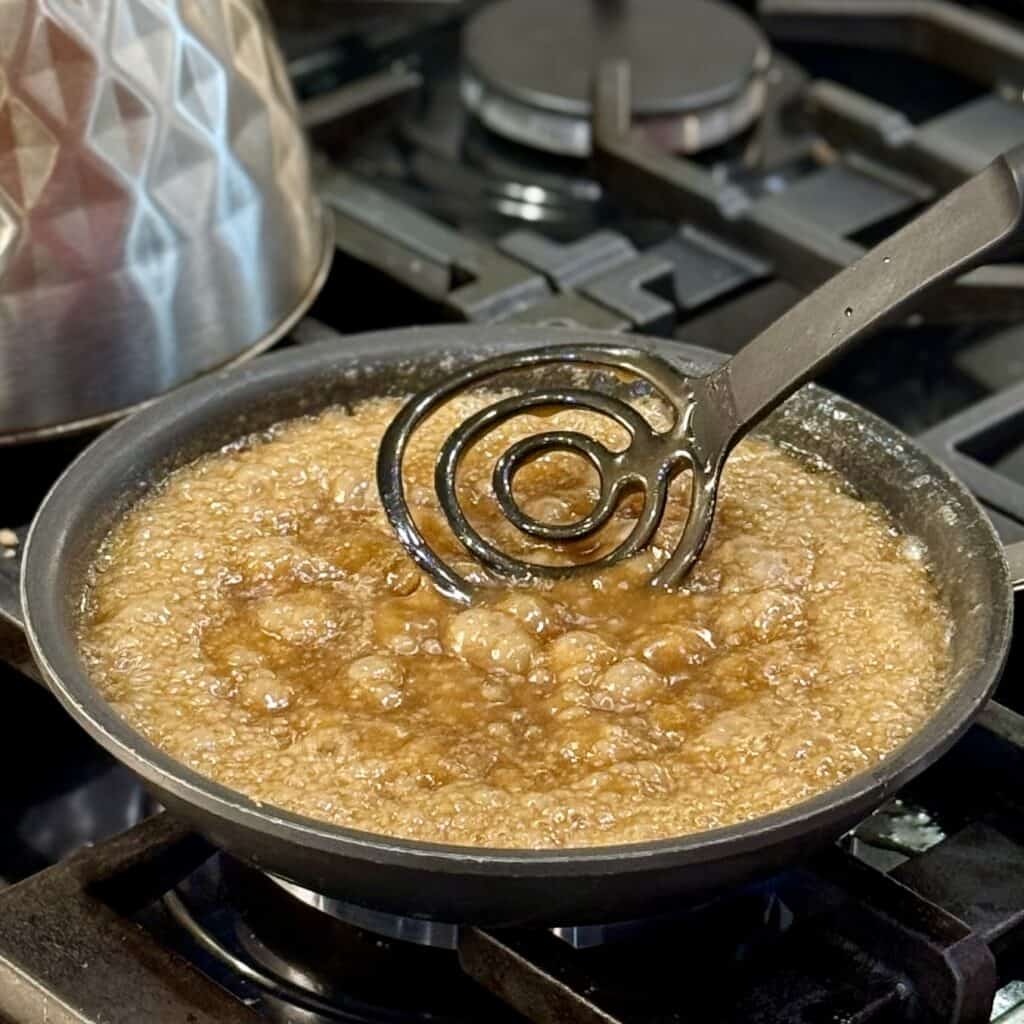 Mixing brown sugar and butter in a skillet.