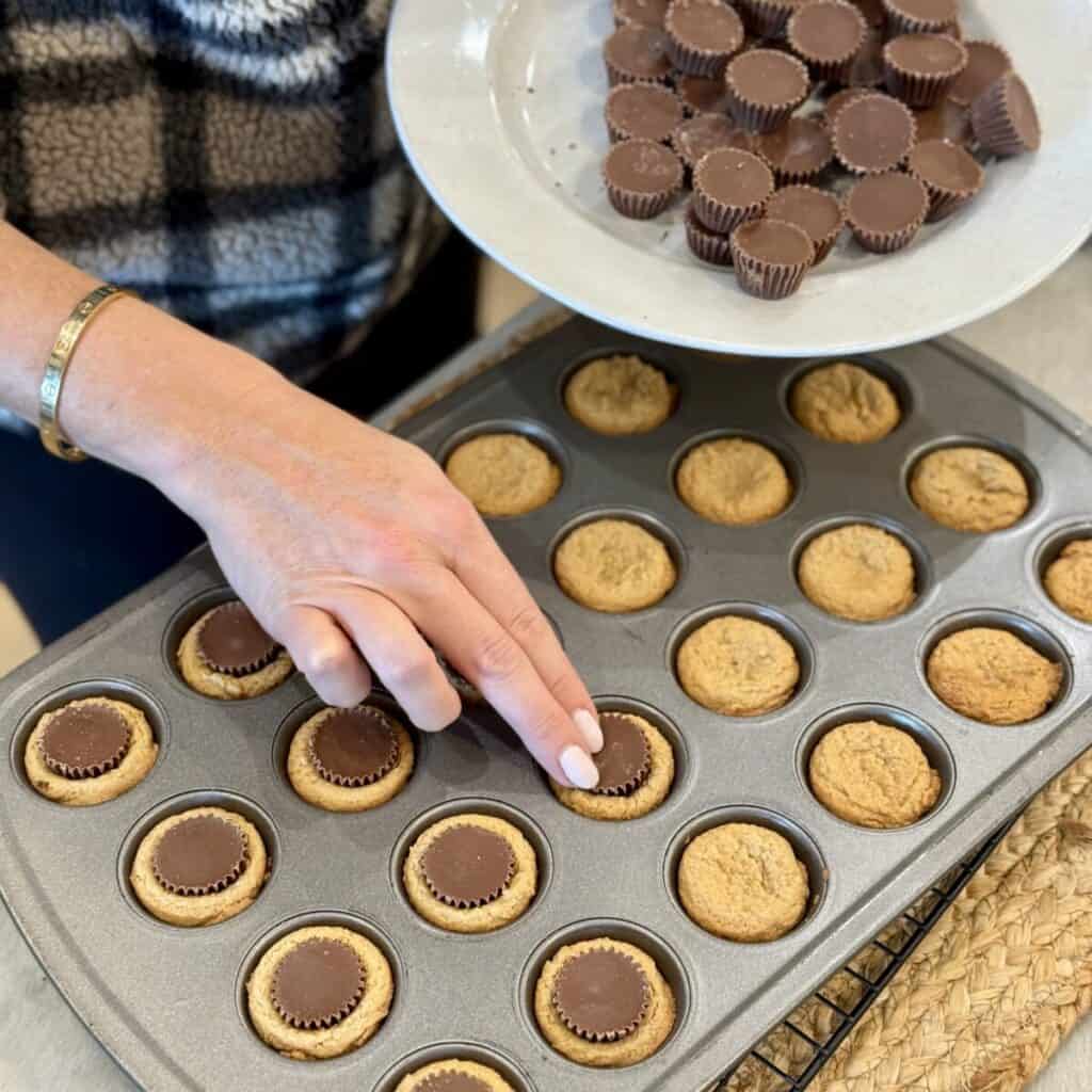 Pressing a peanut butter cup in Peanut Butter Cup Cookies.