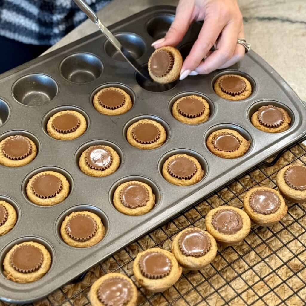 Getting Peanut Butter Cup Cookies out of a muffin pan.