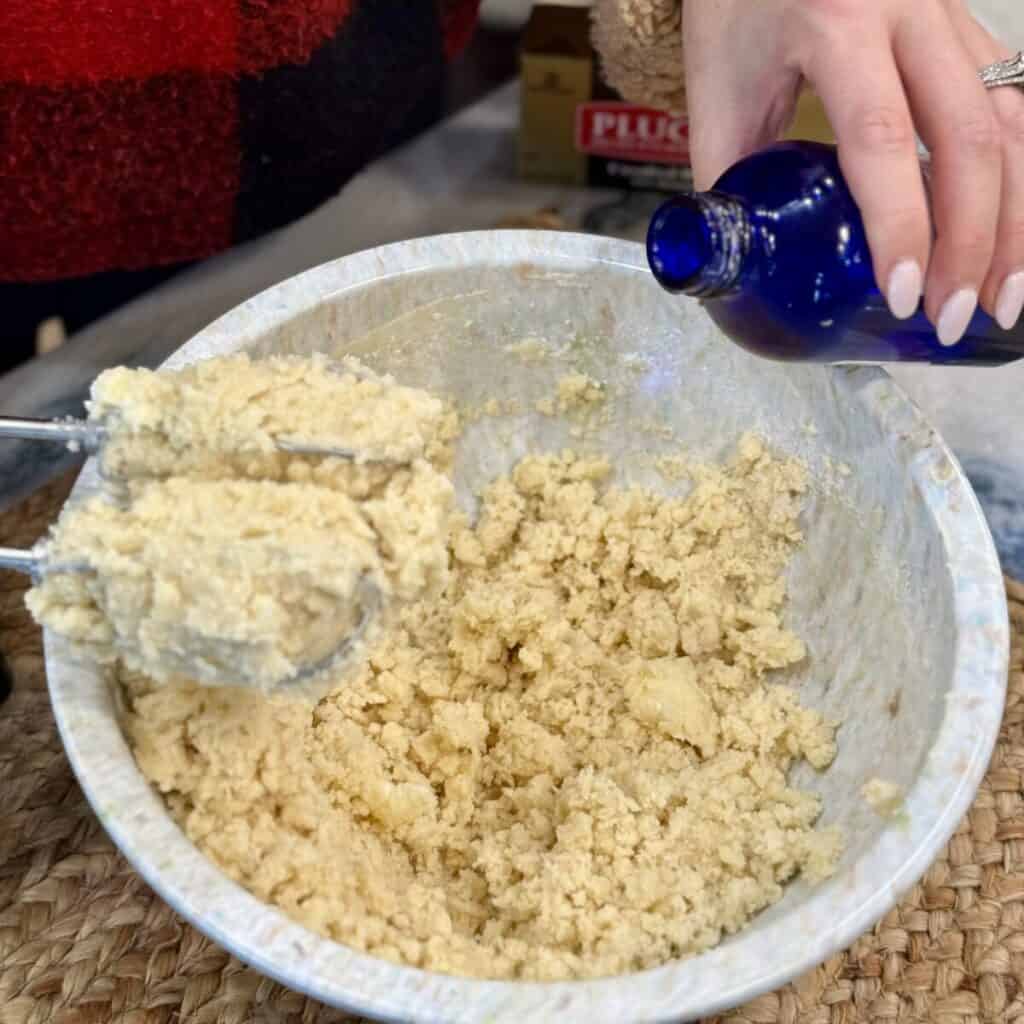 Adding vanilla to raspberry thumbprint cookie dough.