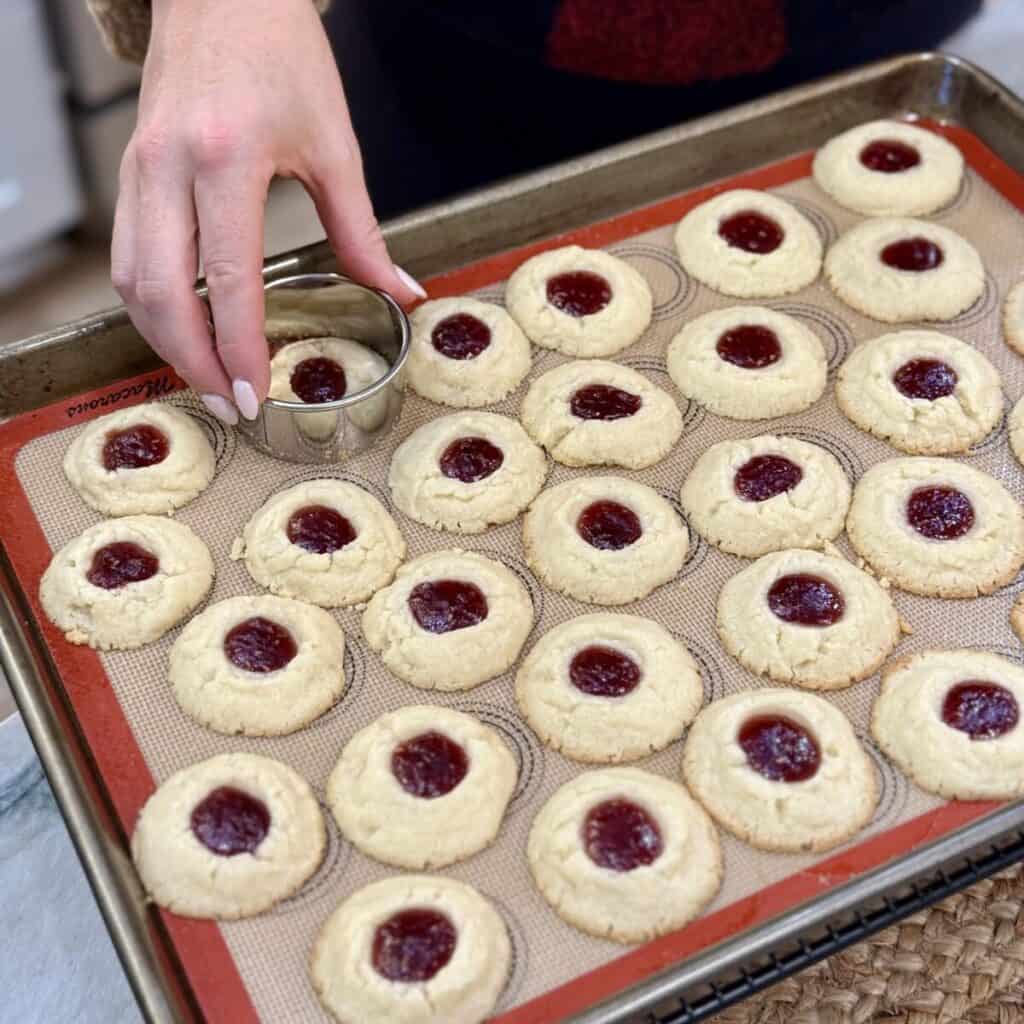 Rounding off the edges of raspberry thumbprint cookie dough.