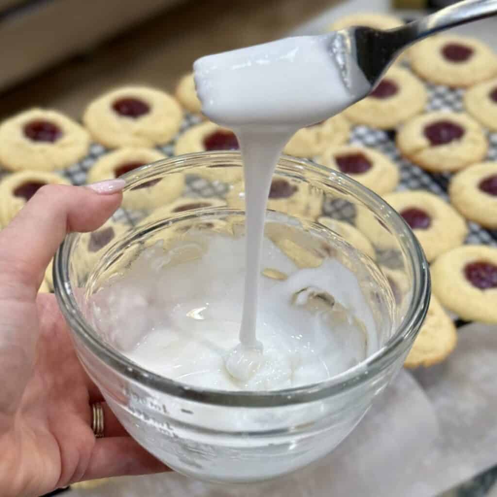Whisking together glaze for raspberry thumbprint cookies.