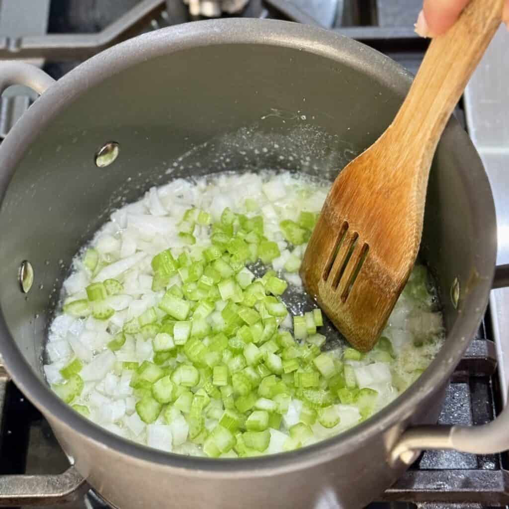 Mixing the ingredients in a pan for buffalo chicken soup.