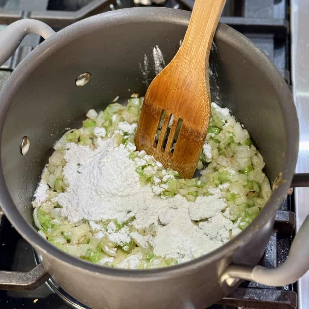 Mixing the ingredients in a pan for buffalo chicken soup.