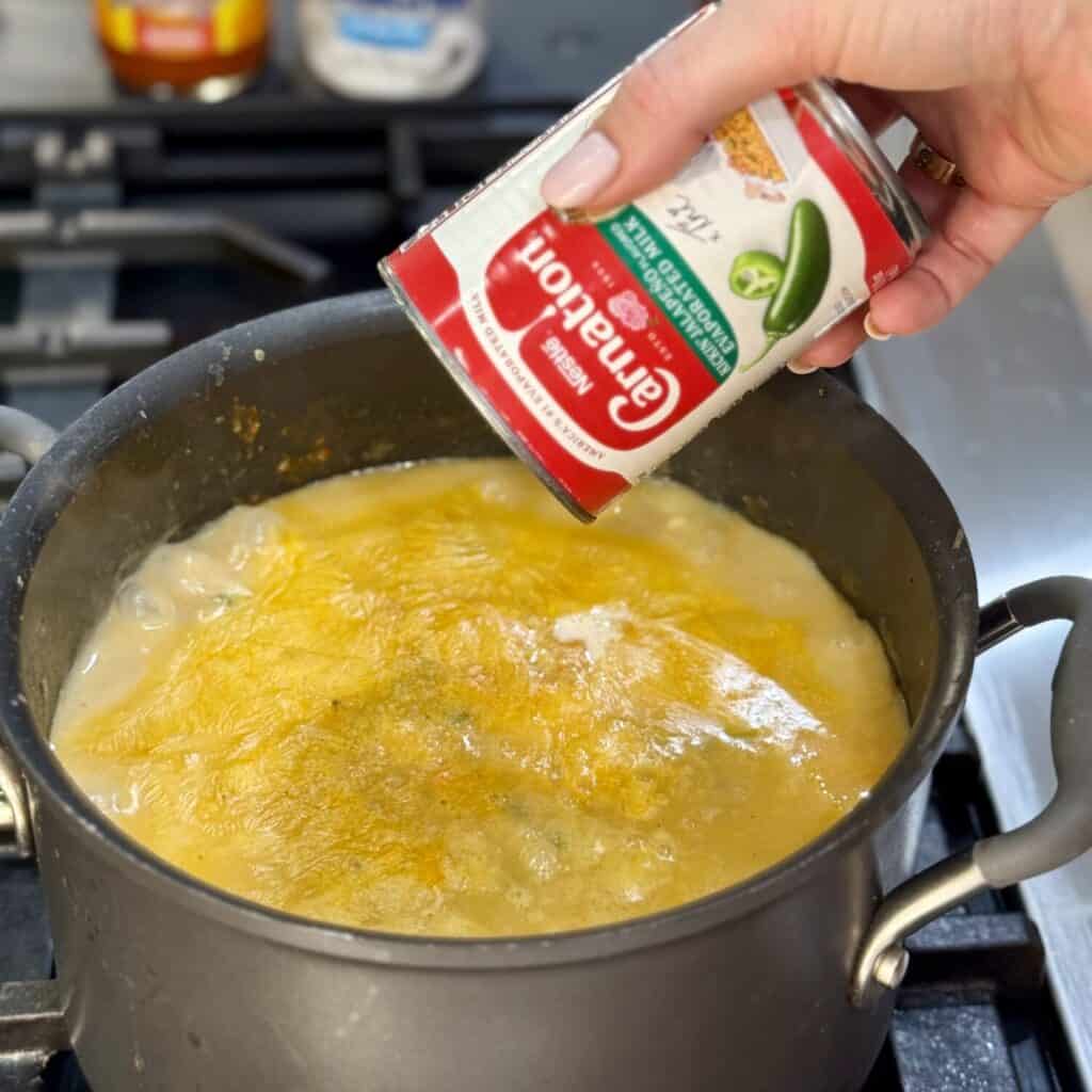 Mixing the ingredients in a pan for buffalo chicken soup.