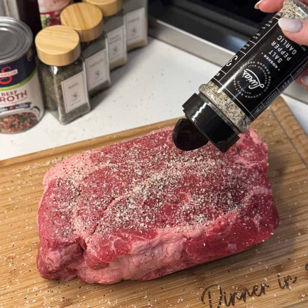 Seasoning a roast on a cutting board.