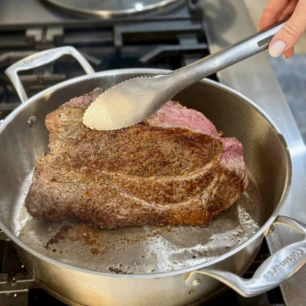 Searing a roast in a pan.