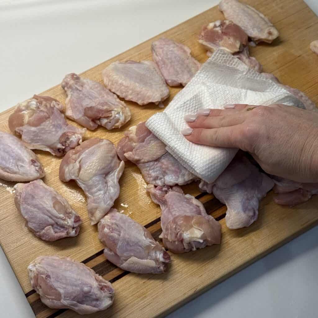 Drying chicken wings on a cutting board.