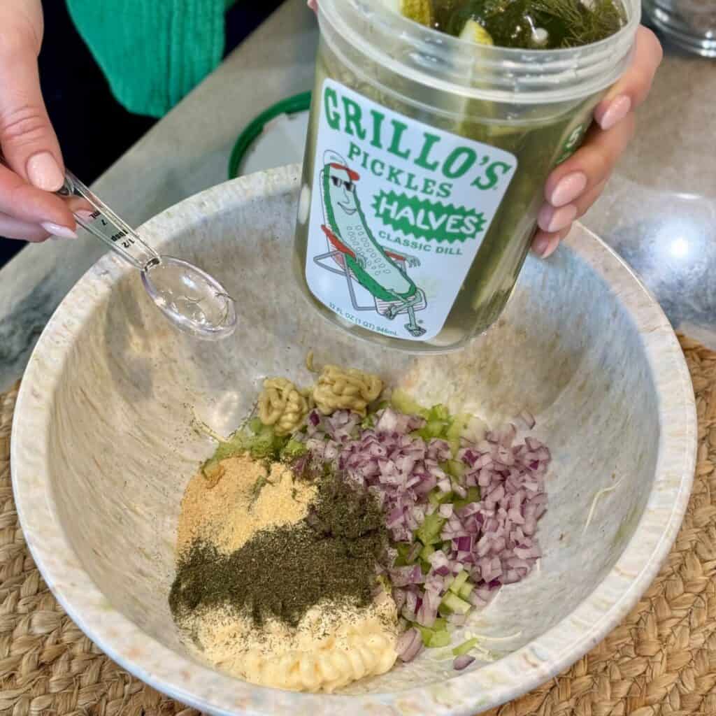 Mixing the ingredients in a bowl for dill pickle chicken salad.