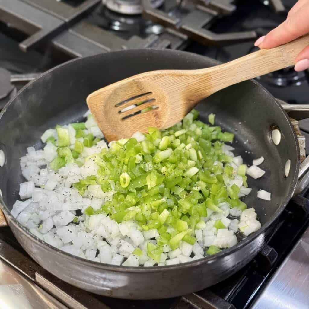 Sautéing onion and pepper in a skillet.