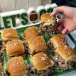 Holding a Philly cheesesteak slider.