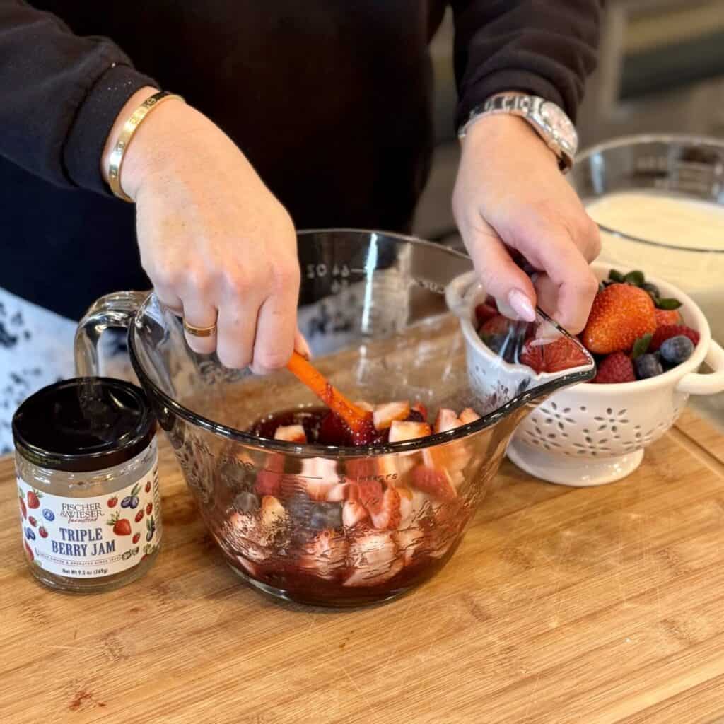 mixing berries for berry trifle.