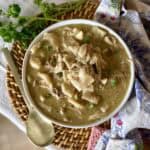 a bowl of chicken and dumplings with canned biscuits.