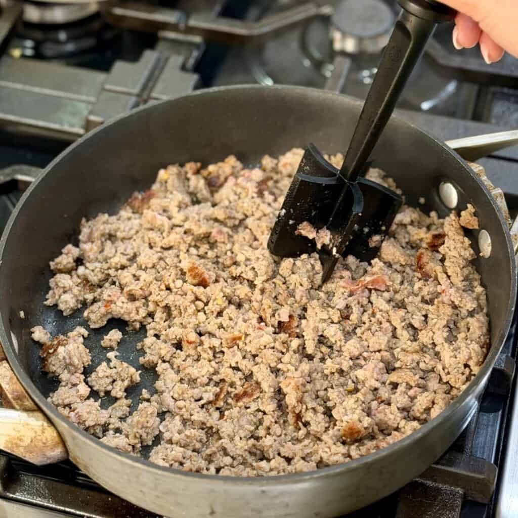 Browning sausage in a pan.