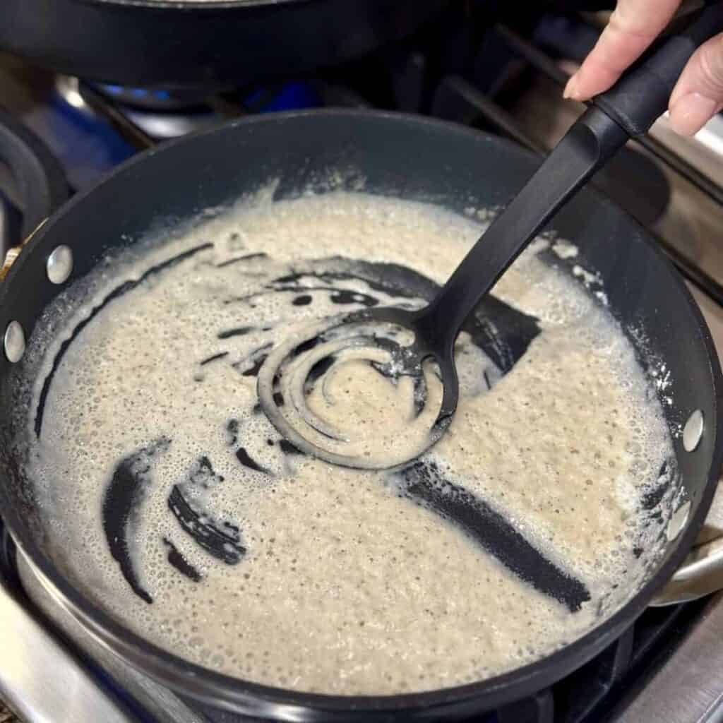 Mixing flour and grease in a skillet.