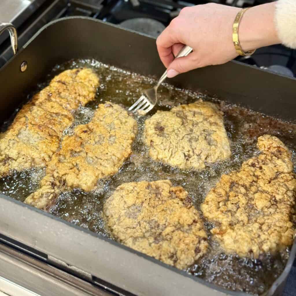 Frying cube steak.