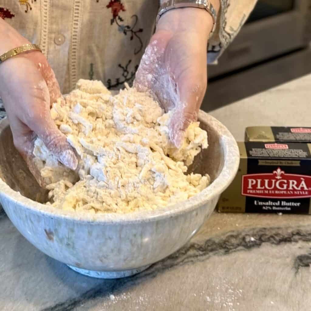 Mixing together flour and butter for a pie crust.