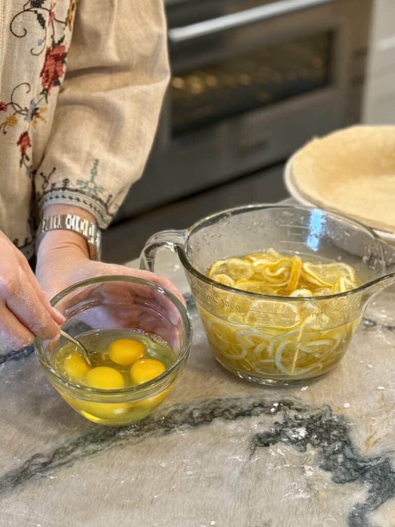 Adding yolks to lemons for a pie.
