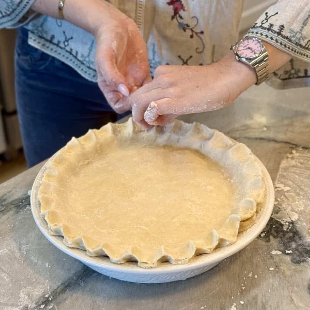 Pinching the edge of a pie crust.