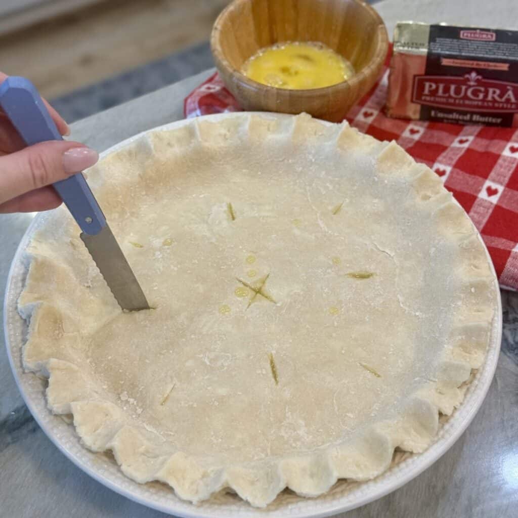 Piercing a pie crust with a knife.