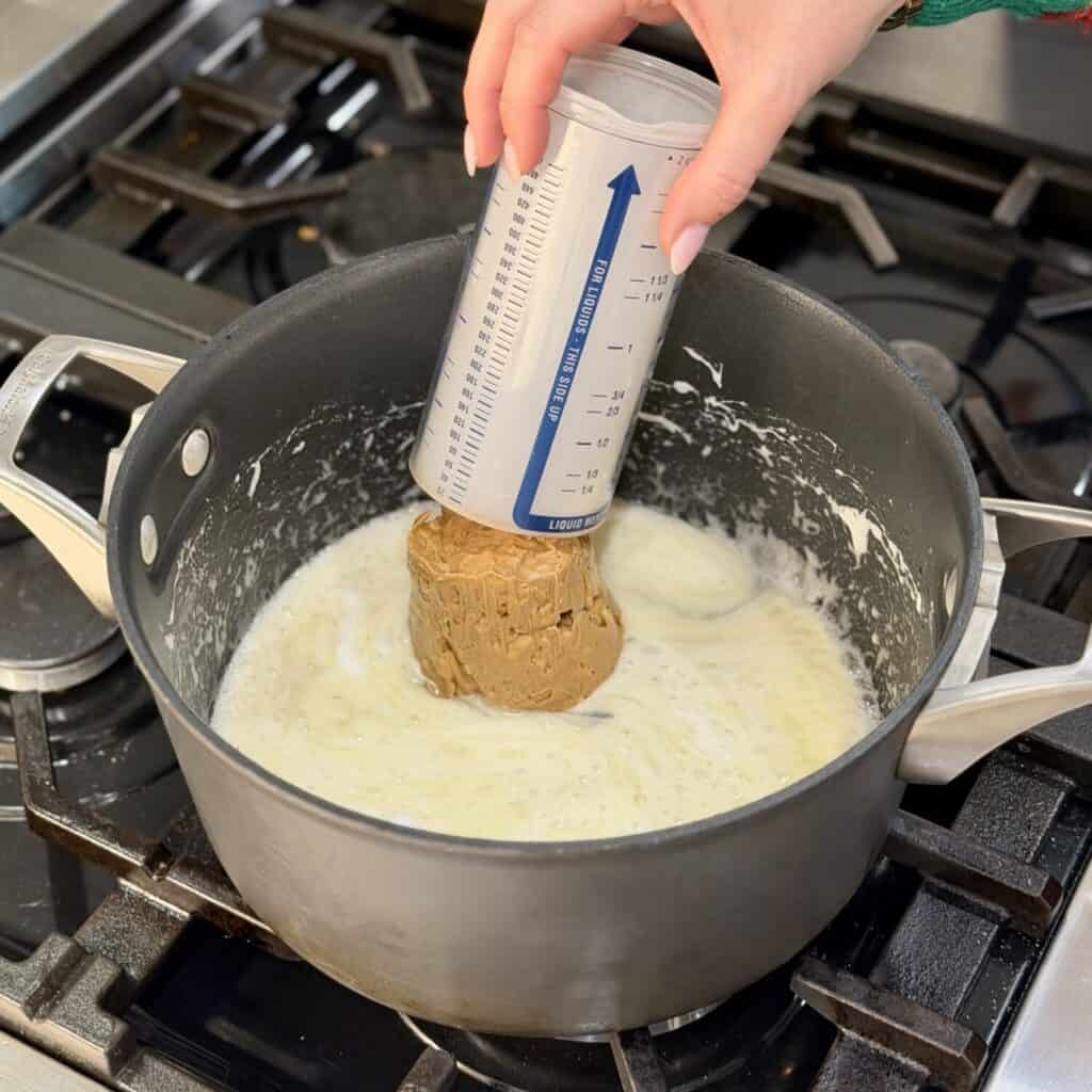 Adding peanut butter to the mixture.
