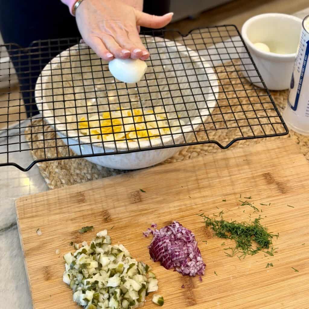 Chopping the ingredients for dill pickle egg salad.